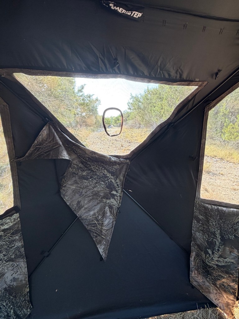 View from inside a hunting blind looking out through the shooting window toward the property.